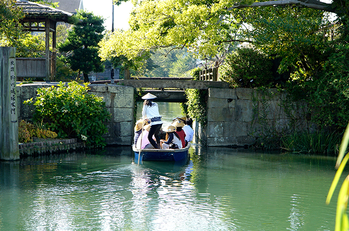  A group of people floating along a river in a traditional boat