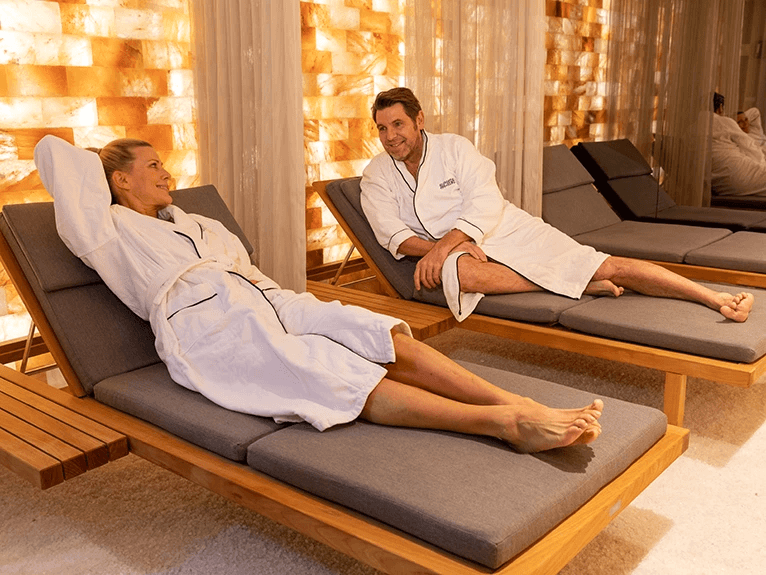 A man and woman lying on a lounger in the Salt Therapy Lounge on a Scenic Space-Ship