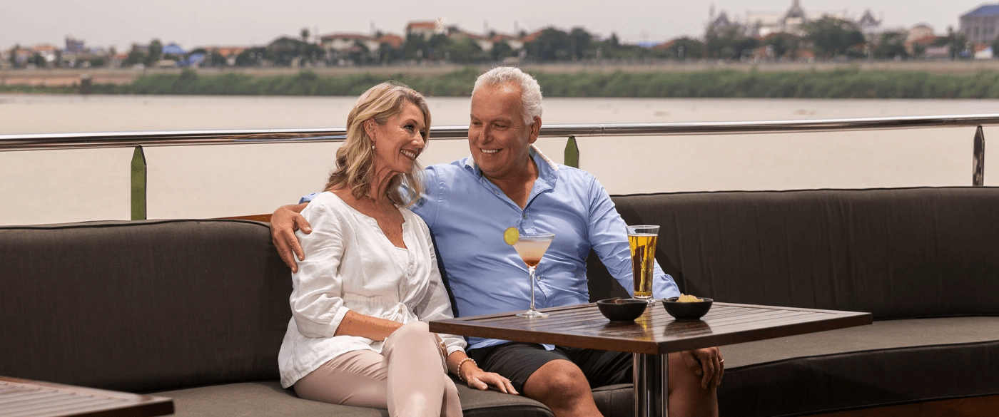  A couple having a beverage on the outdoor deck onboard the Scenic Spirit cruise ship.