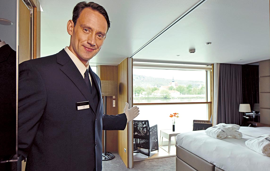 A butler welcoming guests to their suite, Scenic Amber
