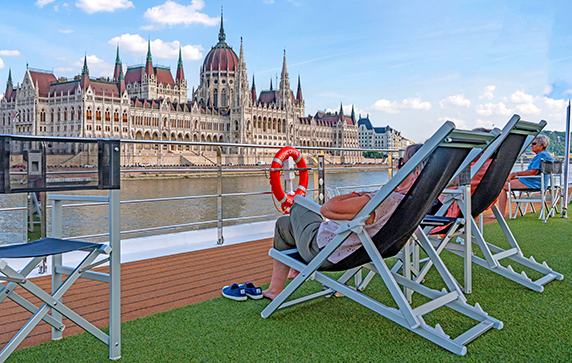 Guests looking at the Hungarian Parliament Building from lounger chairs on a Scenic Space-Ship.