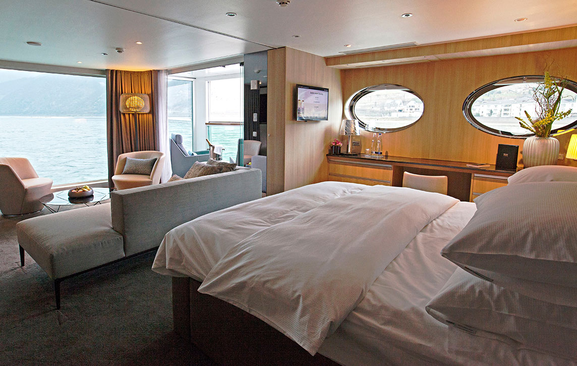 The separate lounge area and Queen bed in the luxurious Royal Panorama Suite on the Scenic Jasper cruise ship.