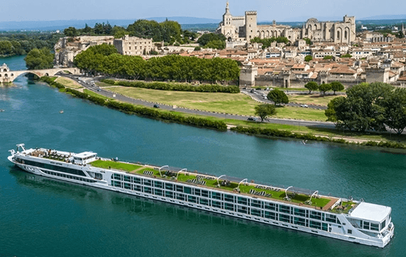 The Scenic Sapphire ship cruising the Rhone River next to the historic city of Avignon, France.