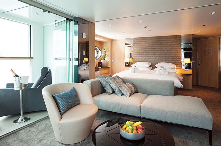 The luxurious lounge area and queen bed in the Royal Panorama Suite on the Scenic Jasper ship.Image 