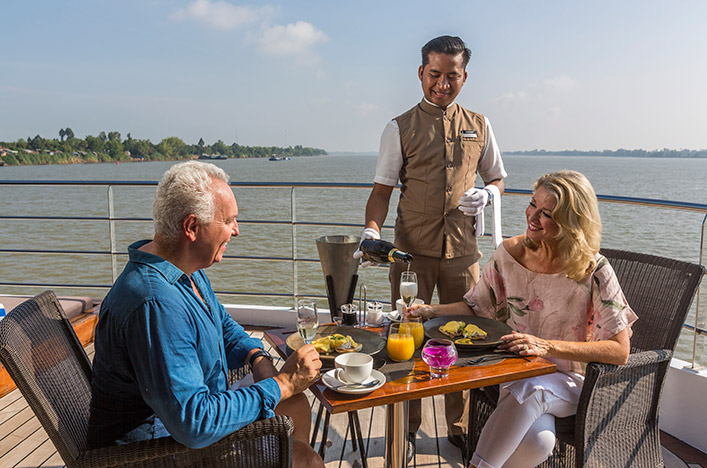 Guests being served breakfast by their personal butler on the terrace of the Royal Panorama Suite, Scenic Spirit 