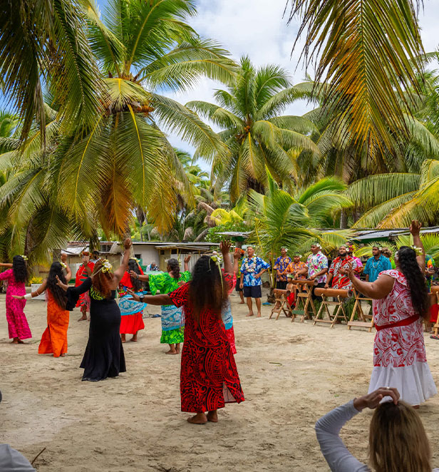 Native people dancing under plam trees in the cook islands