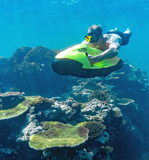 Man under water on a sea bob near coral