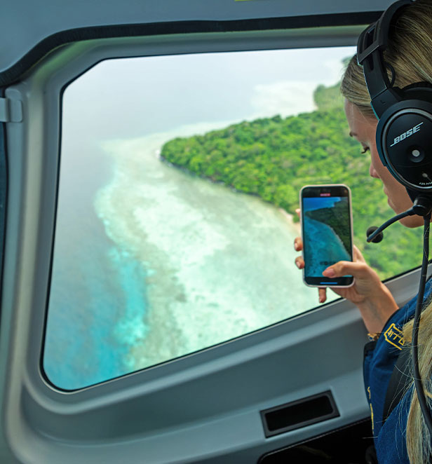 Women in helicopter taking photo of Taveuni Island