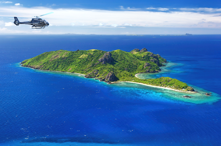 Helicopter flying above island