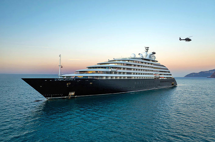 black and white ship in the ocean at sunset with a helicopter