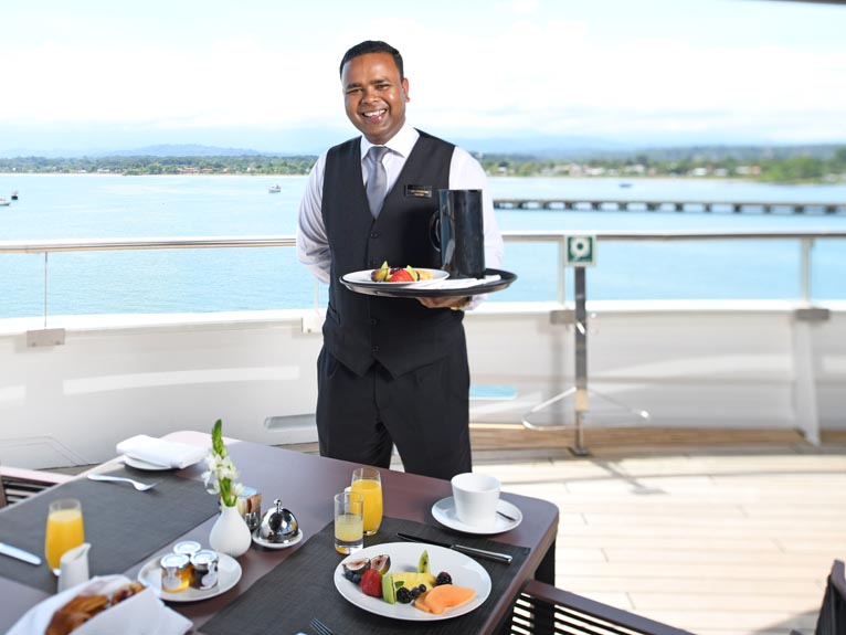 Scenic Eclipse Butler serving breakfast