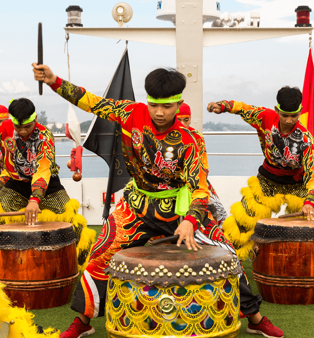 Traditional Asian drummers in vibrant costumes performing a cultural drum show on board Scenic Spirit